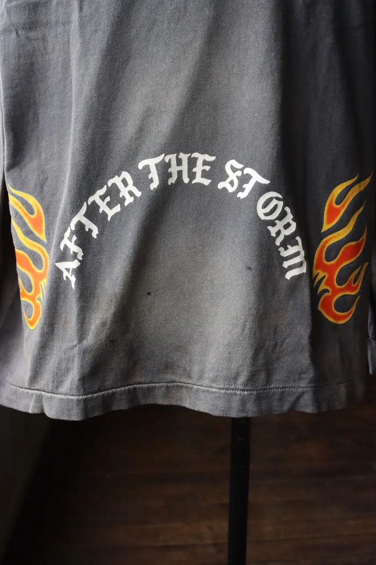 SAINT Mxxxxxx M/AFTER LS_TEE/BLACK Flame arrow Letter M retro distressed long tee Washed black S-XL Tubular fabric Assute ready-made garments dyed The whole piece is sprayed with horse-hair spray and then sprayed again to fade the color. The collar and cuffs are frayed. Many places are frayed. Extra large printing position. Very difficult to print. Complete accessories. With little angel anti-counterfeiting label.